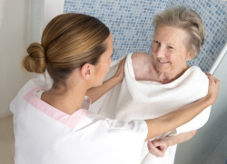 elderly woman taking a bath with her caregiver